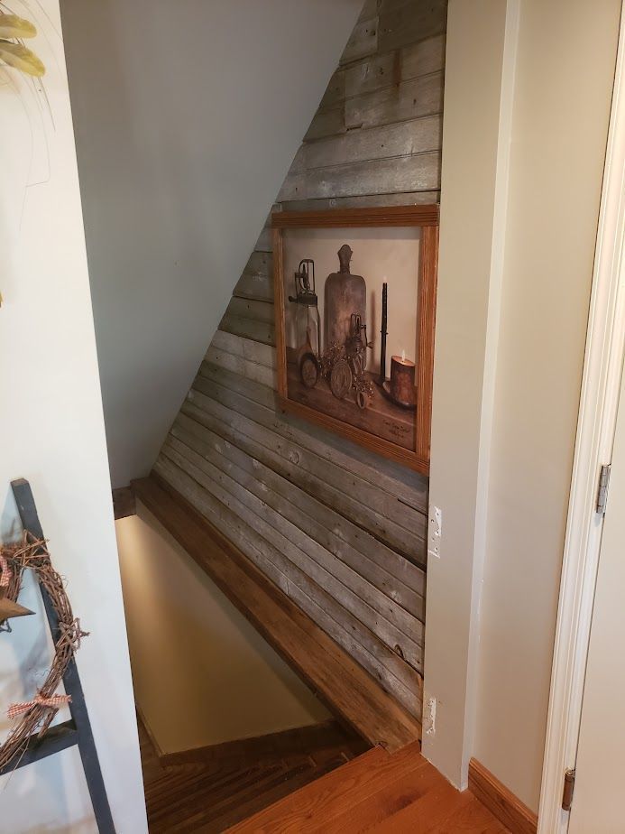 A picture is hanging on a wall next to a staircase.