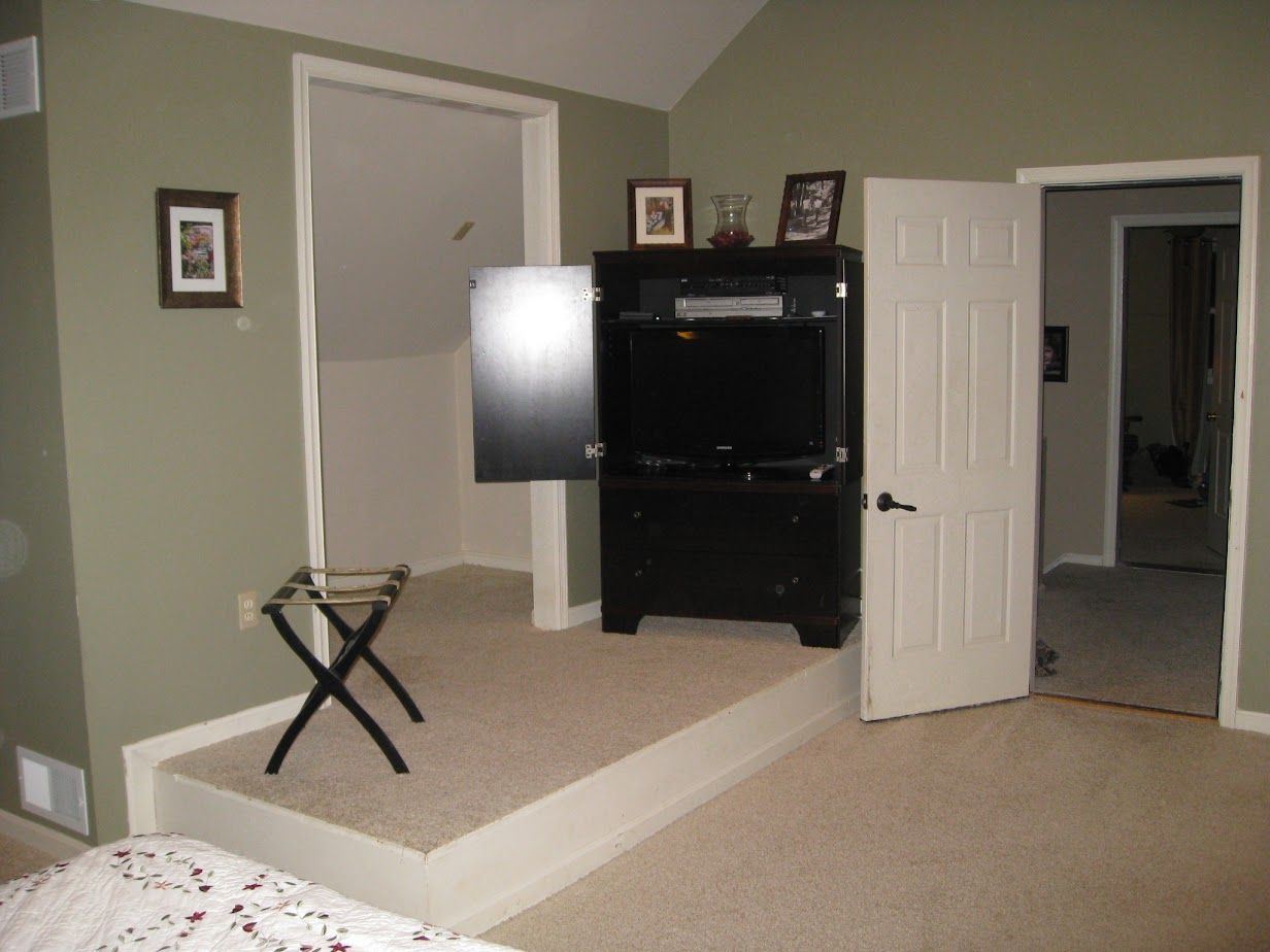 A bedroom with a tv on a stand in the corner