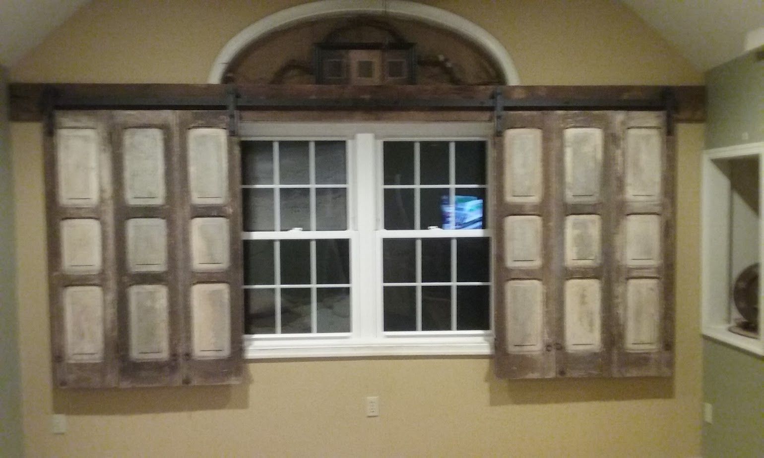 A window with sliding wooden shutters on it