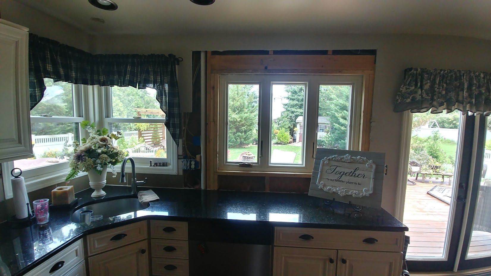 A kitchen with black counter tops and sliding glass doors