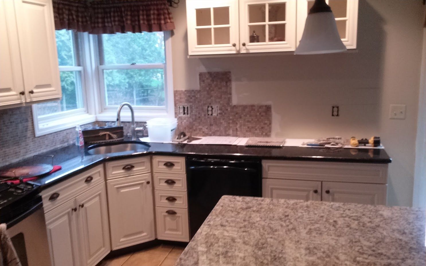 A kitchen with white cabinets and granite counter tops