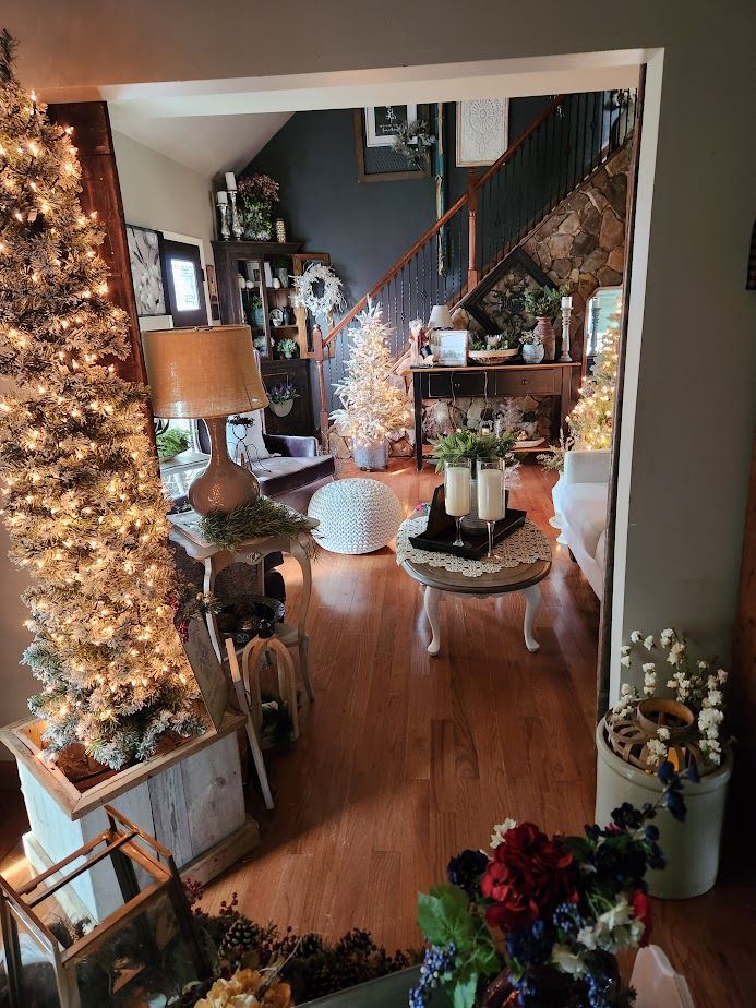 A living room decorated for christmas with a staircase and a christmas tree.