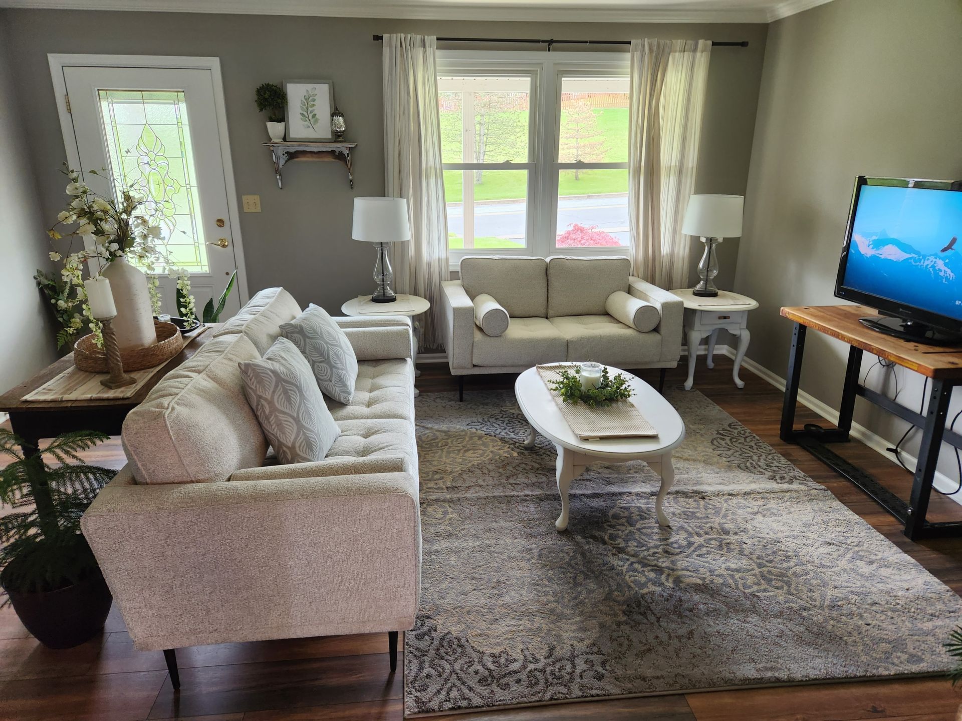 A living room with a couch , chair , coffee table and television.