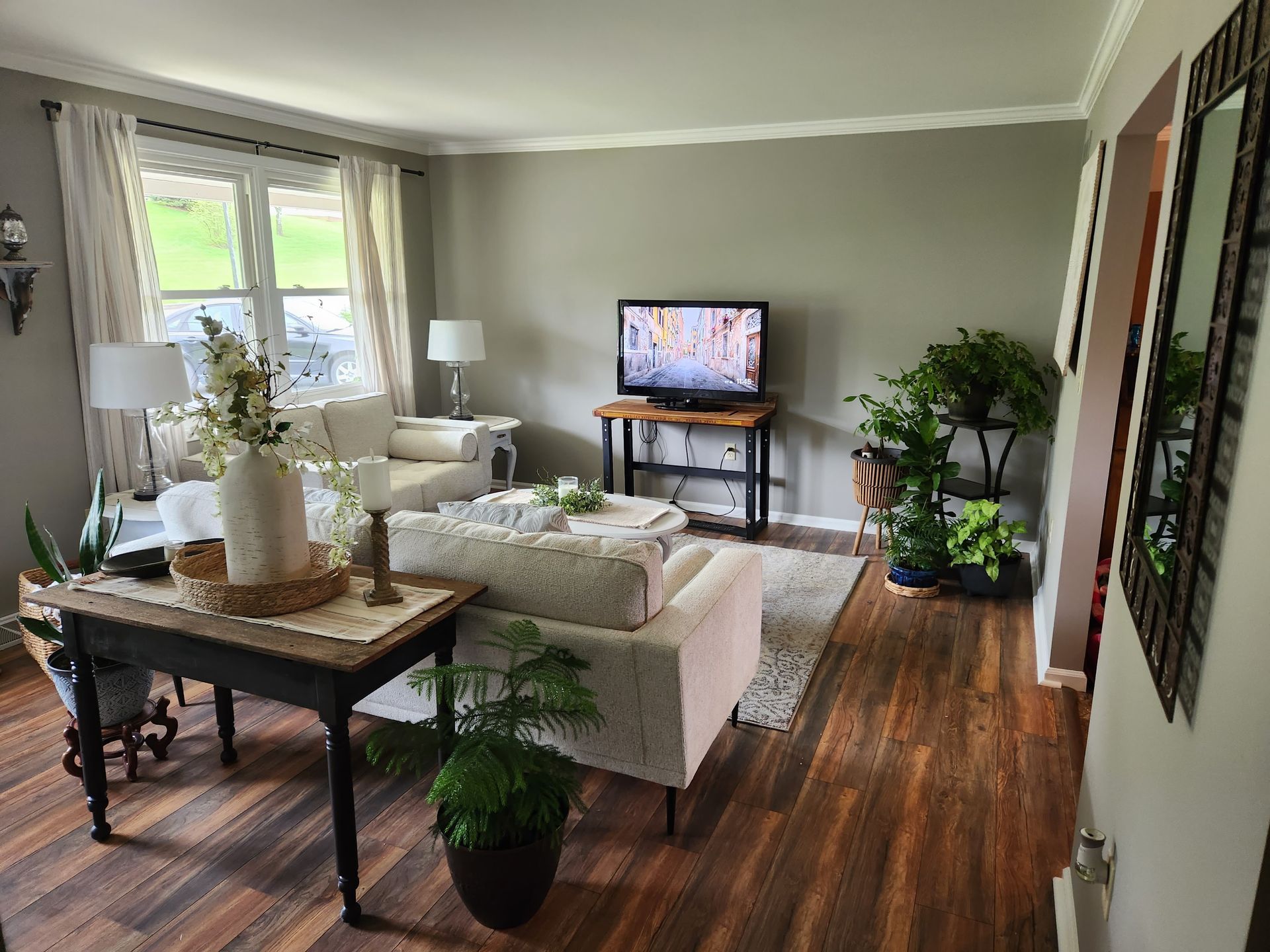 A living room with a couch , chairs , table and television.