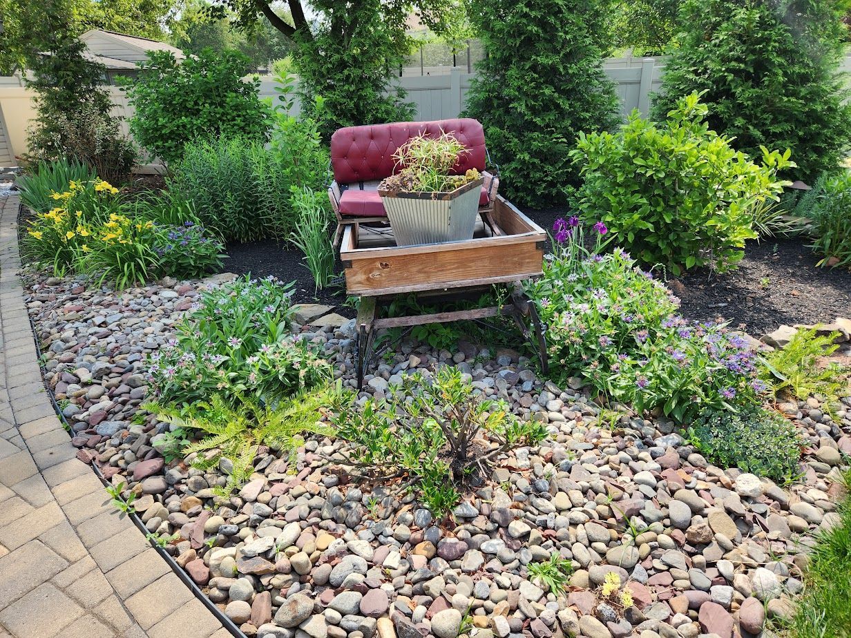 A wheelbarrow filled with potted plants in a garden.