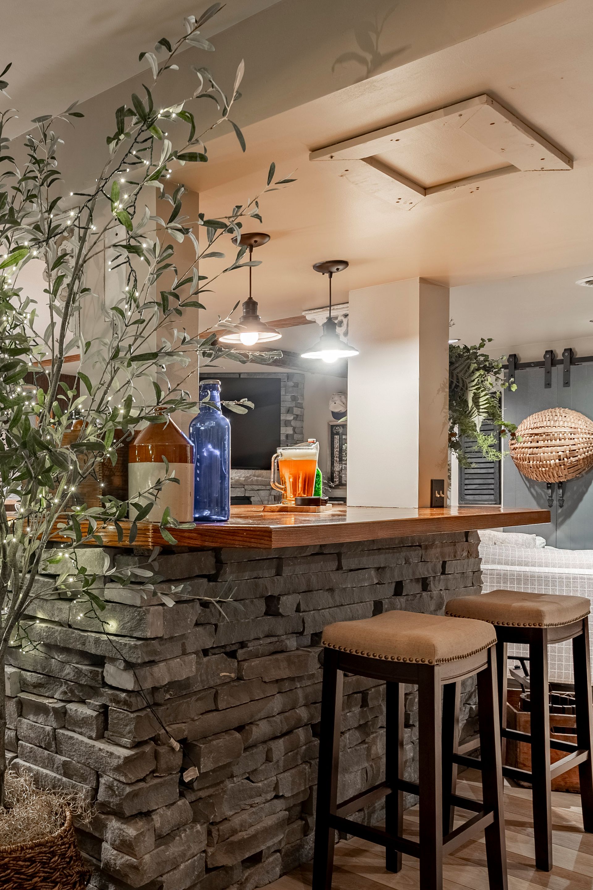 A kitchen with a bar and stools and a brick wall.