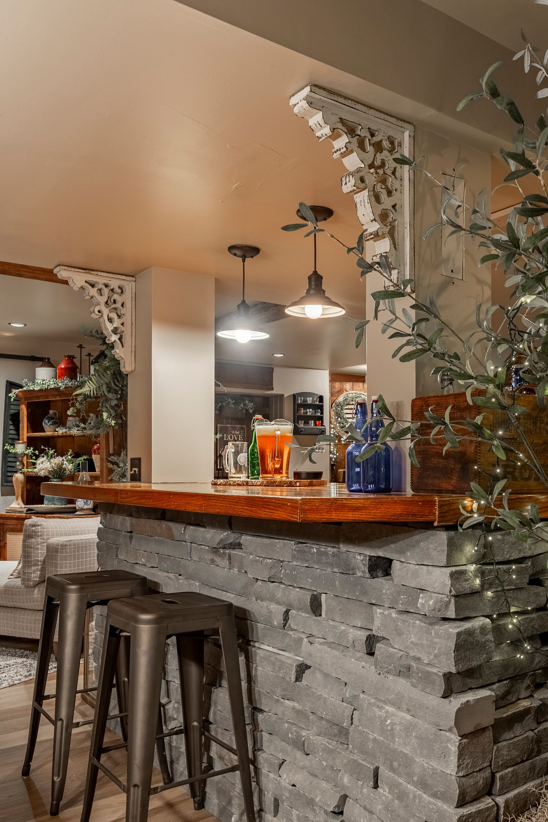 A kitchen with a bar and stools and a brick wall.