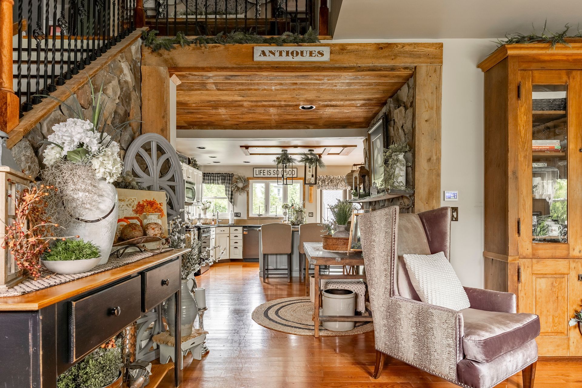 A living room with a chair and a staircase leading to the kitchen.