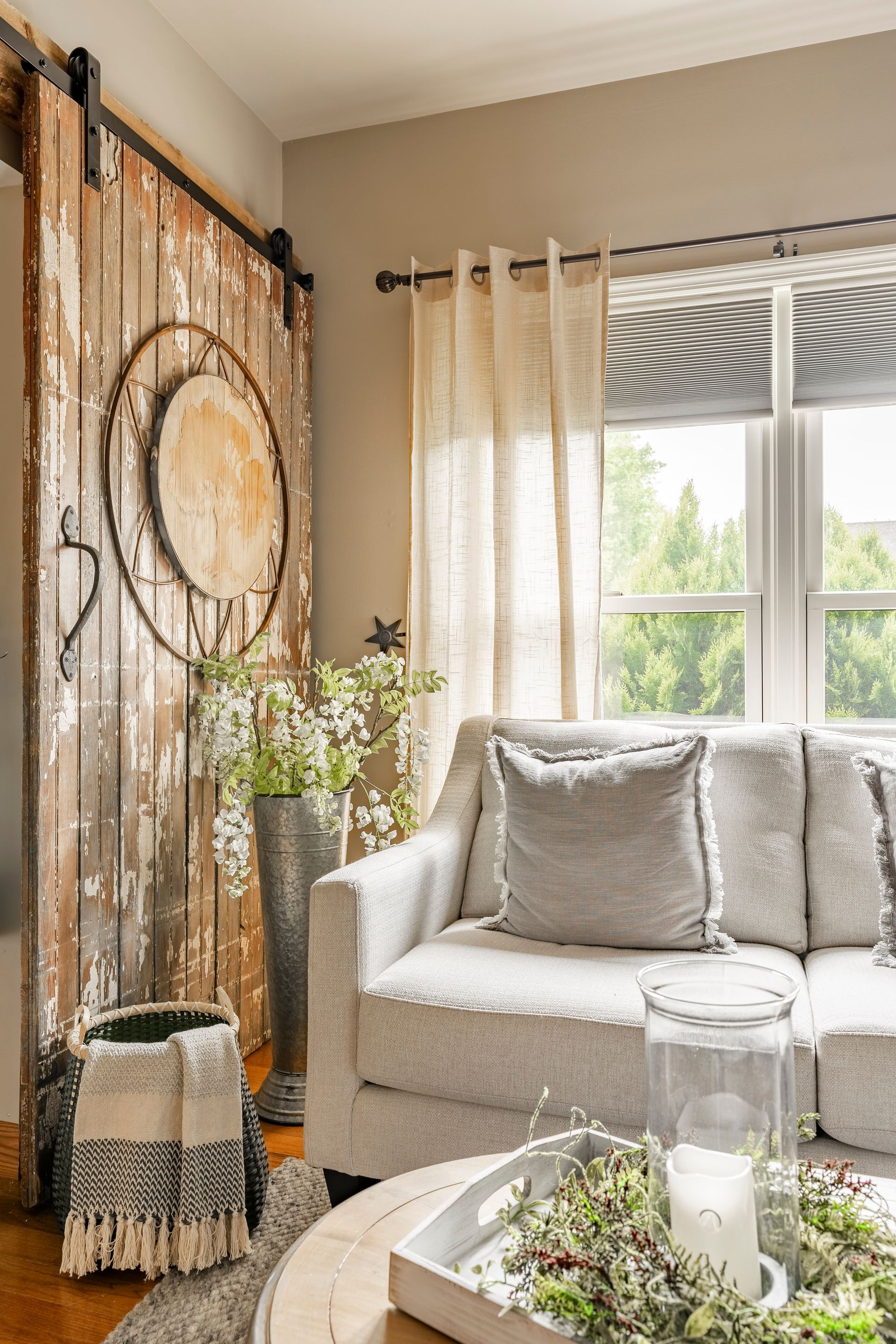 A living room with a couch , table , and sliding barn door.