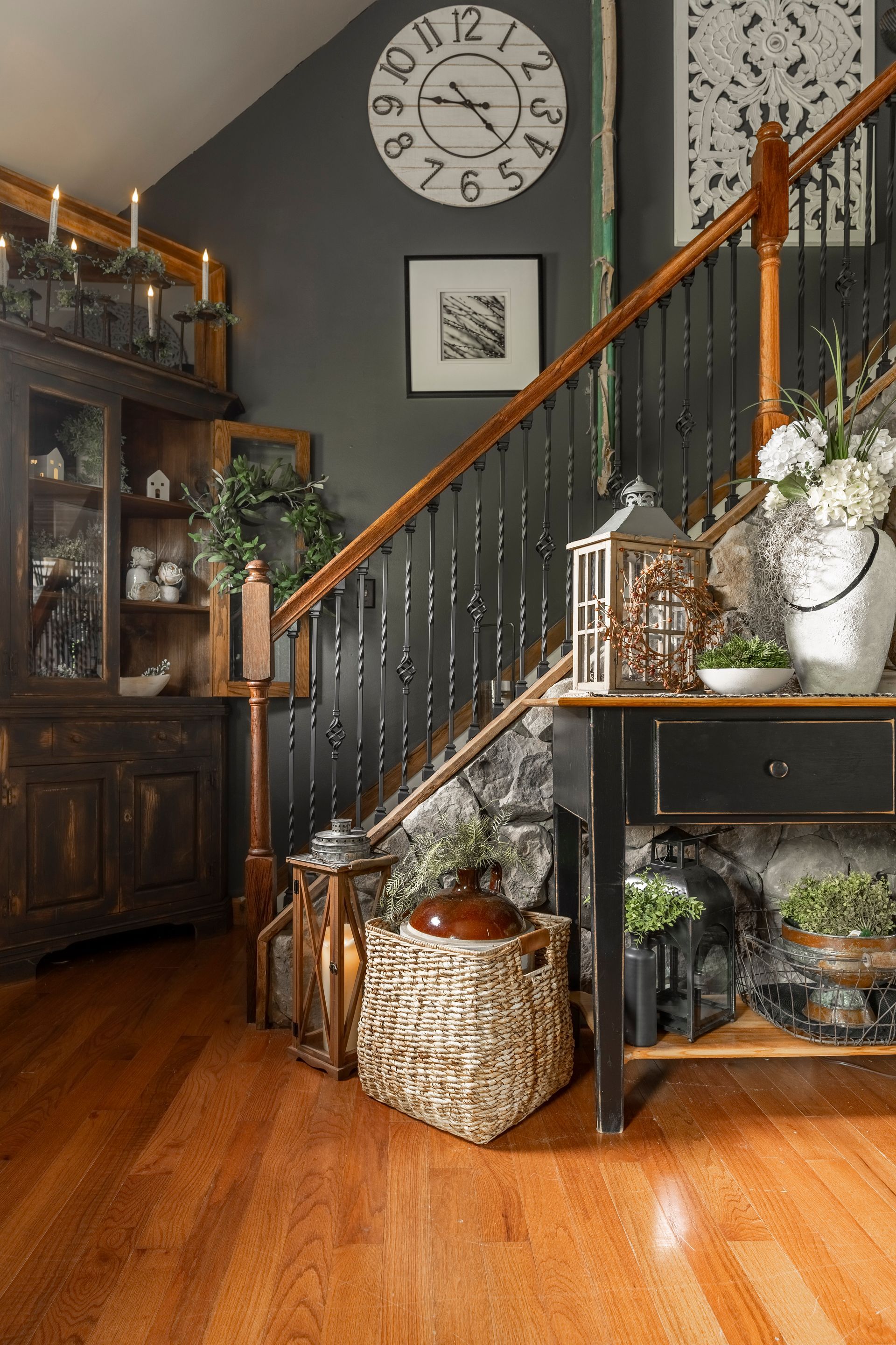 There is a clock on the wall above the stairs.