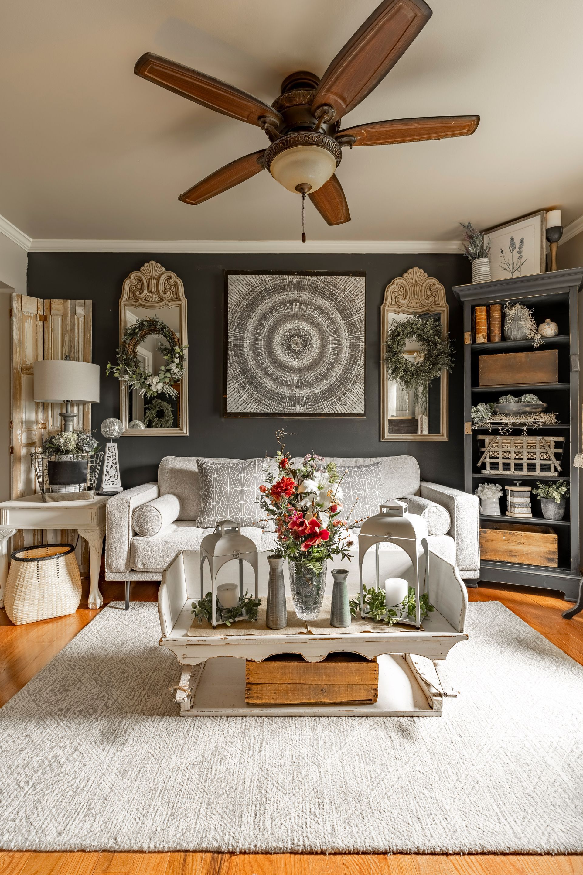 A living room with a couch , coffee table , and ceiling fan.