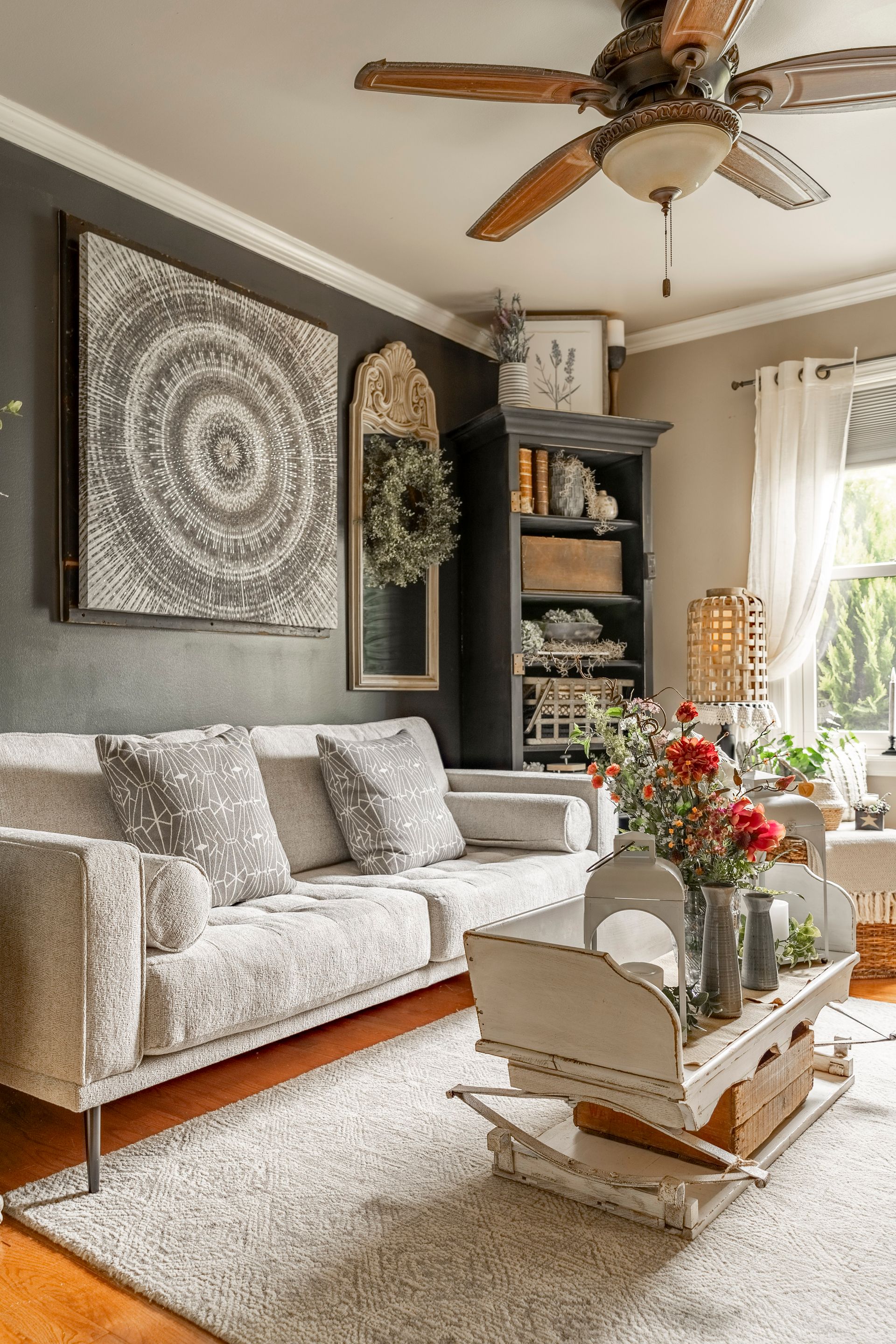 A living room with a couch , coffee table , and ceiling fan.