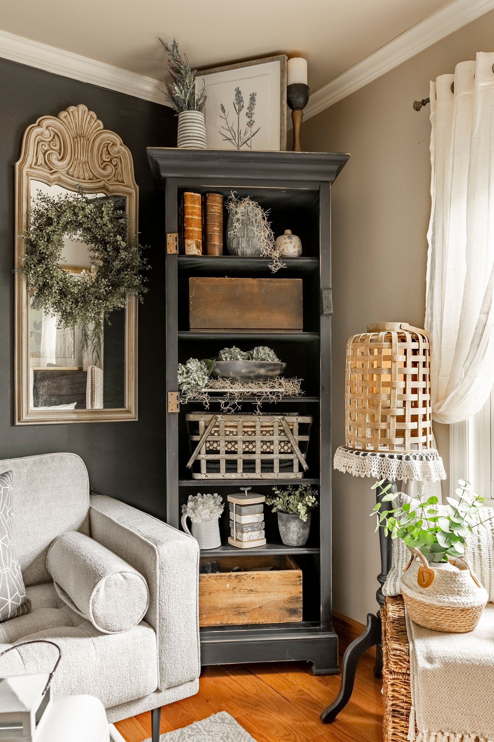 A living room with a bookshelf , chair , and mirror.