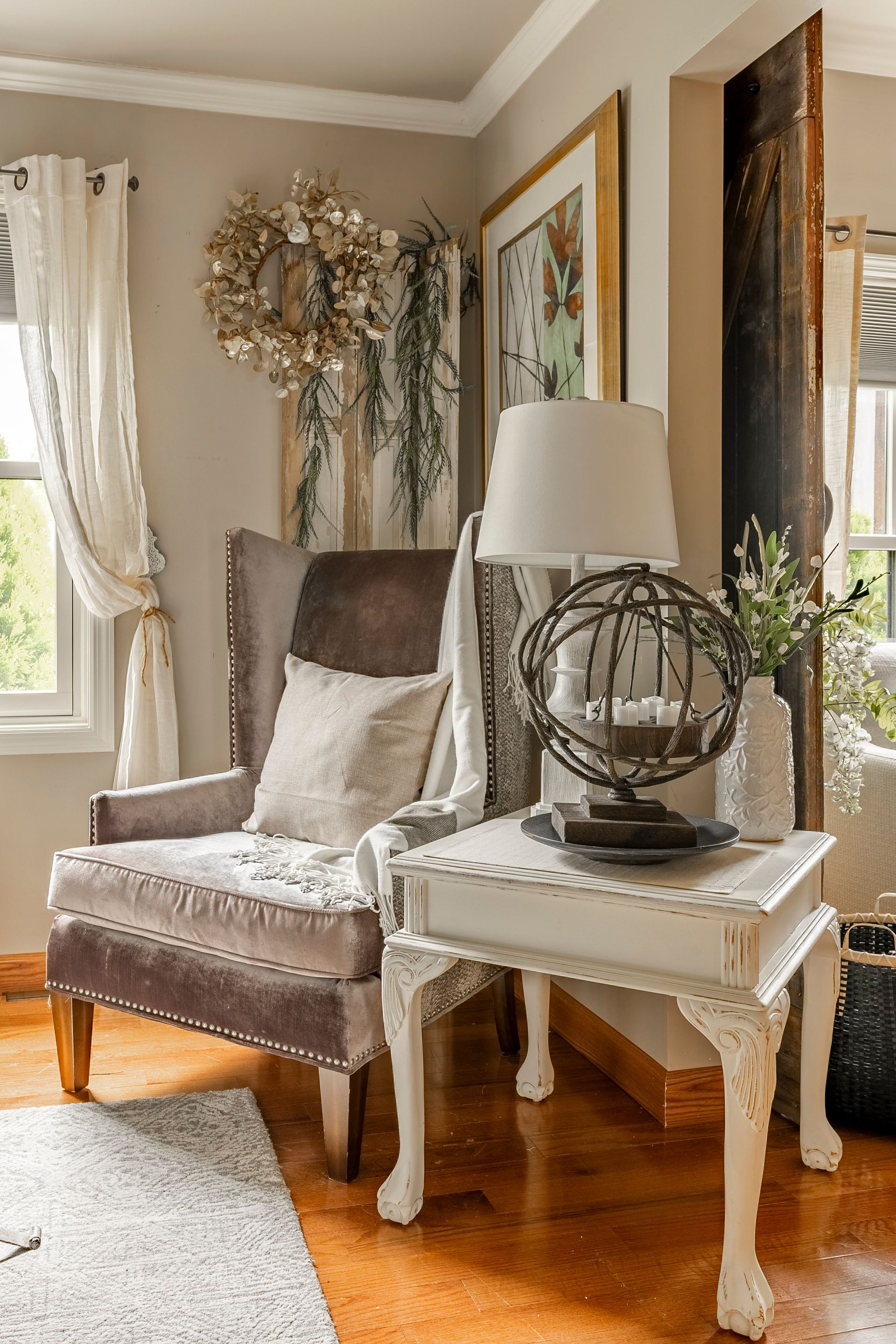 A living room with a chair , table and lamp.