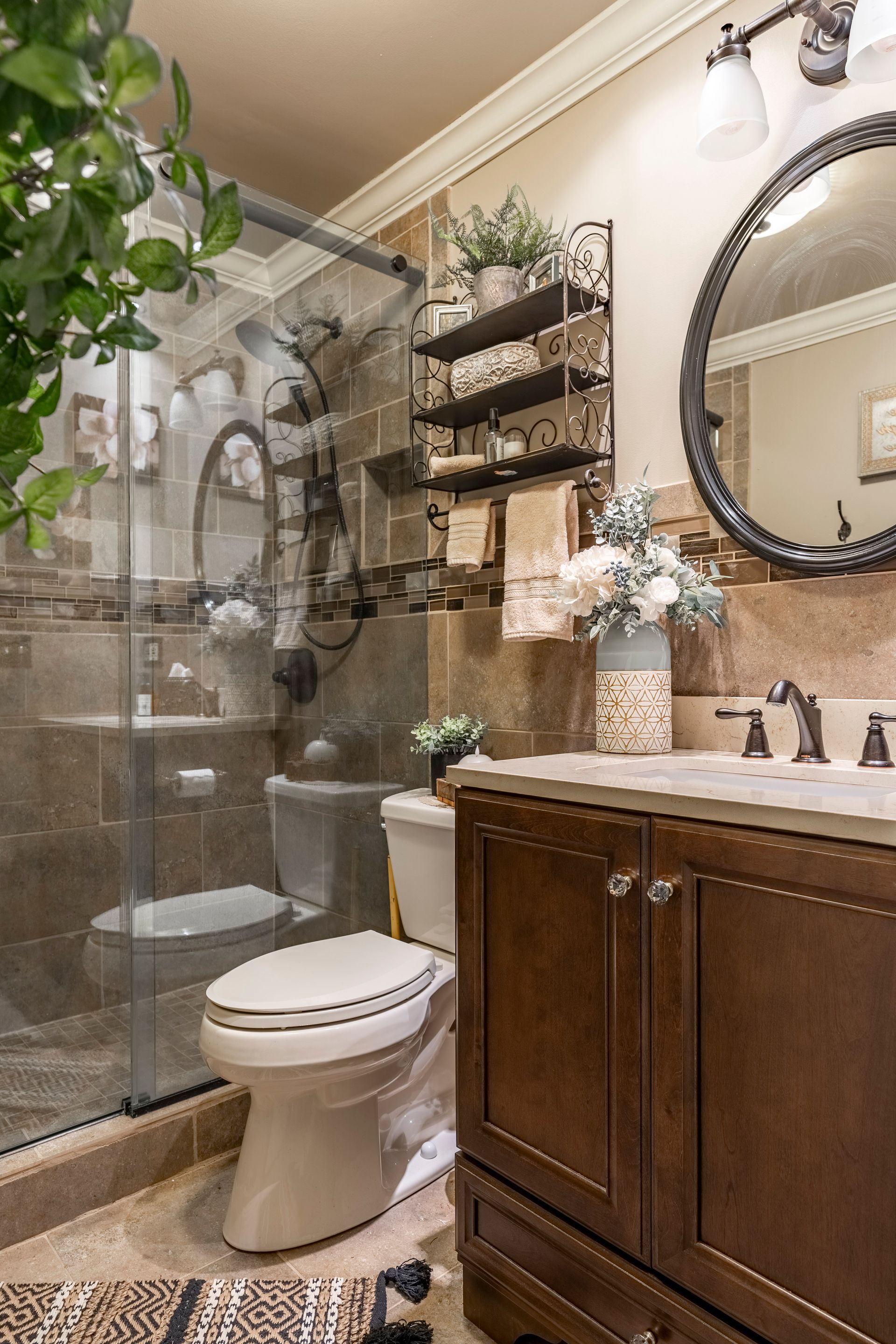 A bathroom with a toilet , sink , mirror and shower.