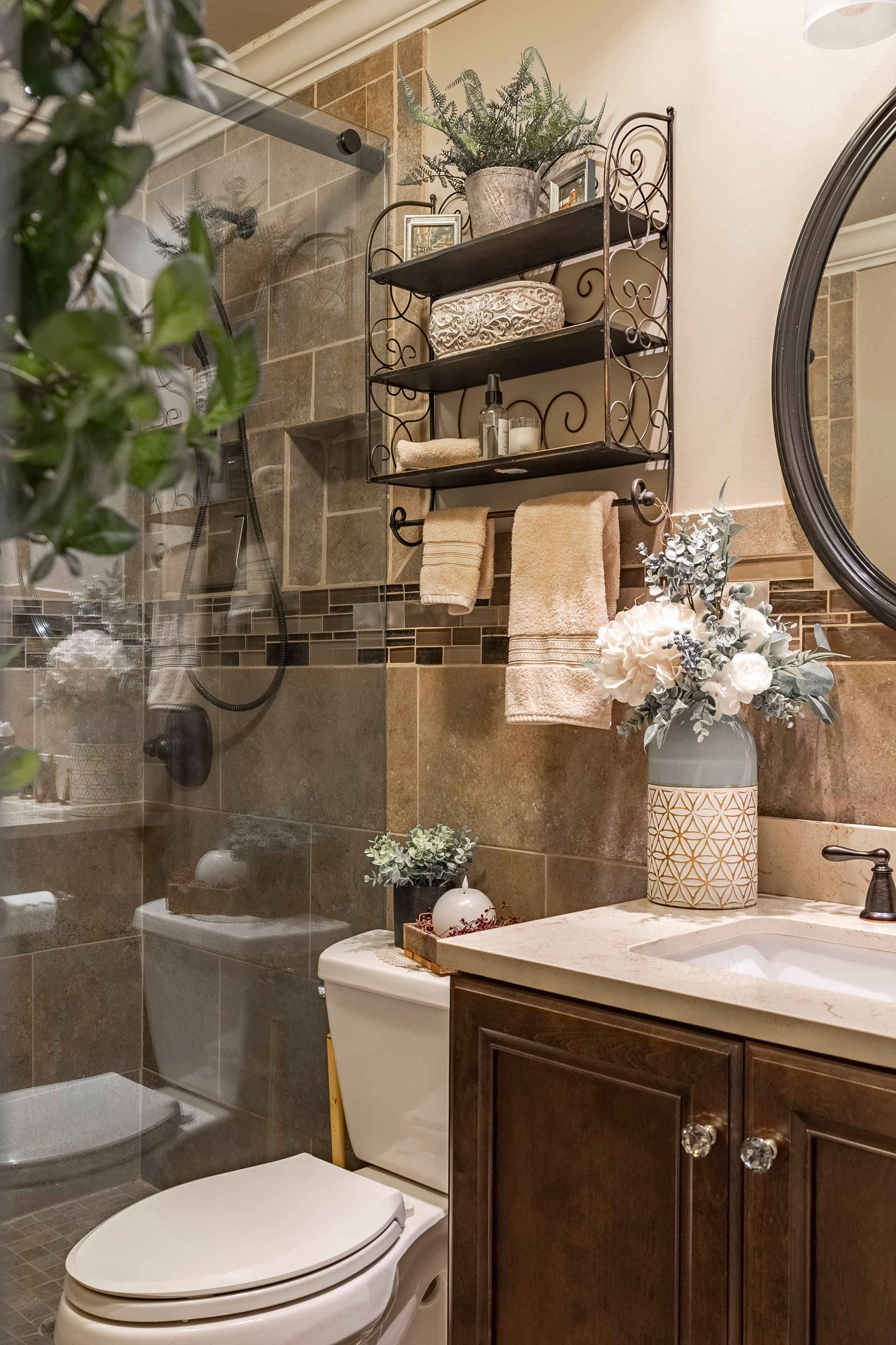 A bathroom with a toilet , sink , mirror and shower.