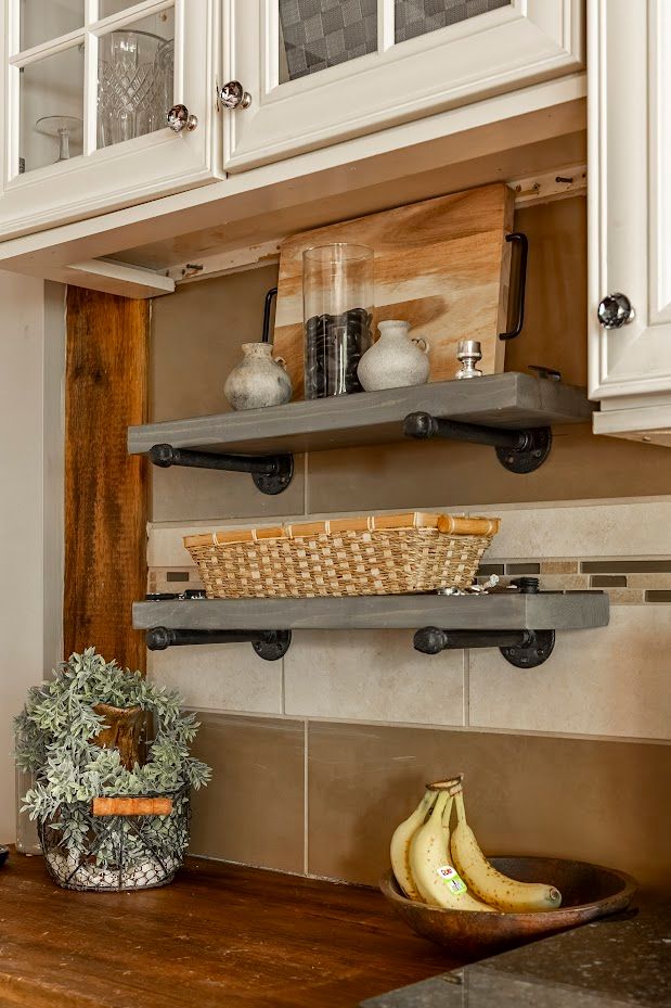 A kitchen with two shelves and a bowl of bananas on the counter.