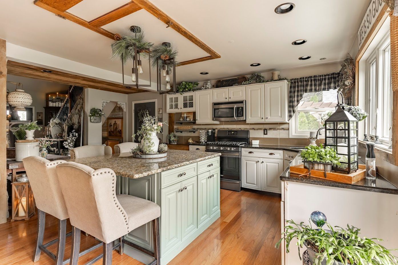 A kitchen with white cabinets , granite counter tops , stainless steel appliances and a large island.