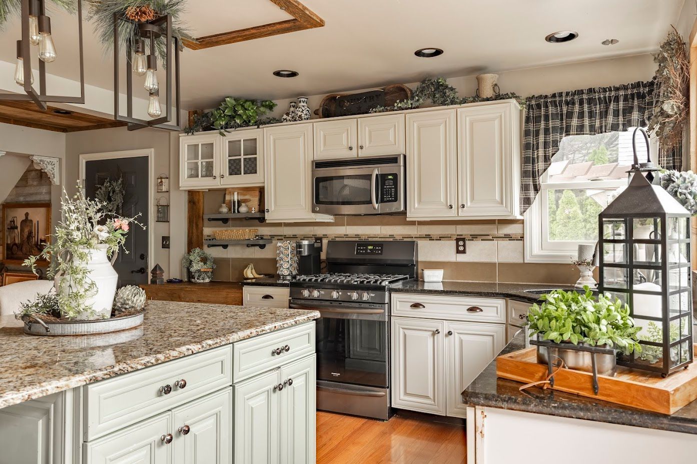 A kitchen with white cabinets , granite counter tops , stainless steel appliances and a large island.