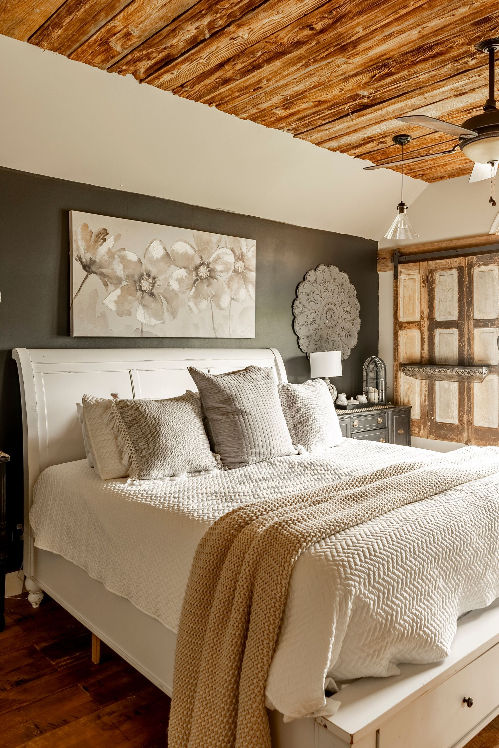 A bedroom with a bed and a wooden ceiling.