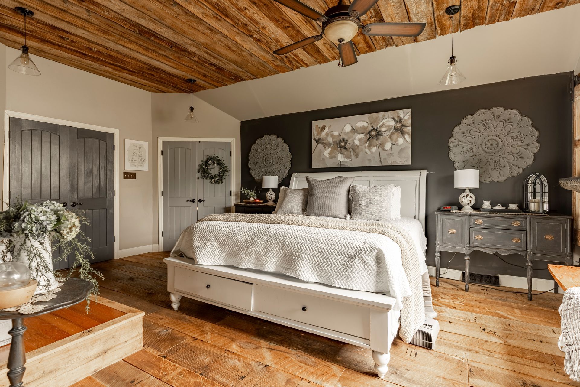 A bedroom with a bed , dresser , nightstand and ceiling fan.