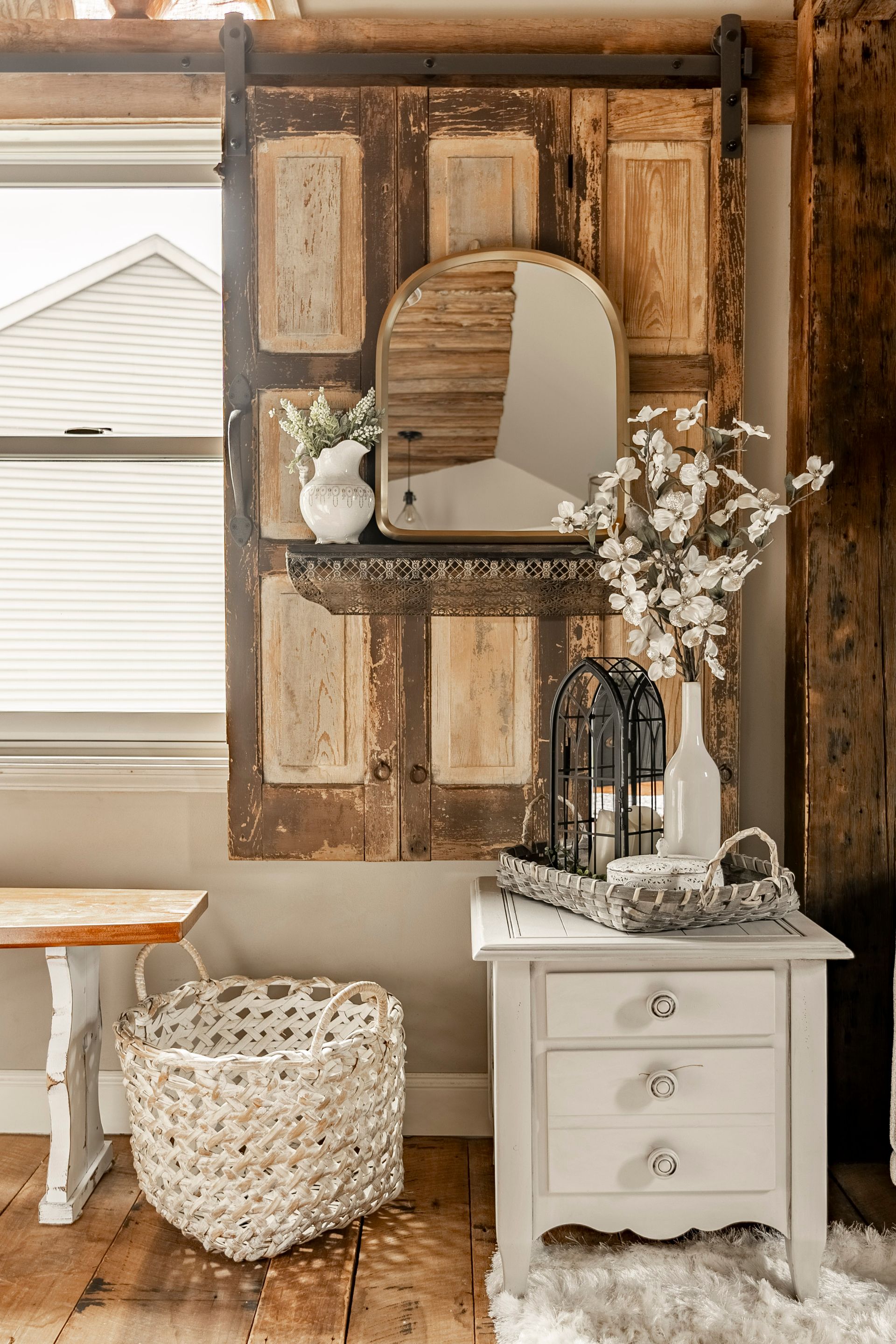 There is a mirror hanging on the wall above a nightstand.