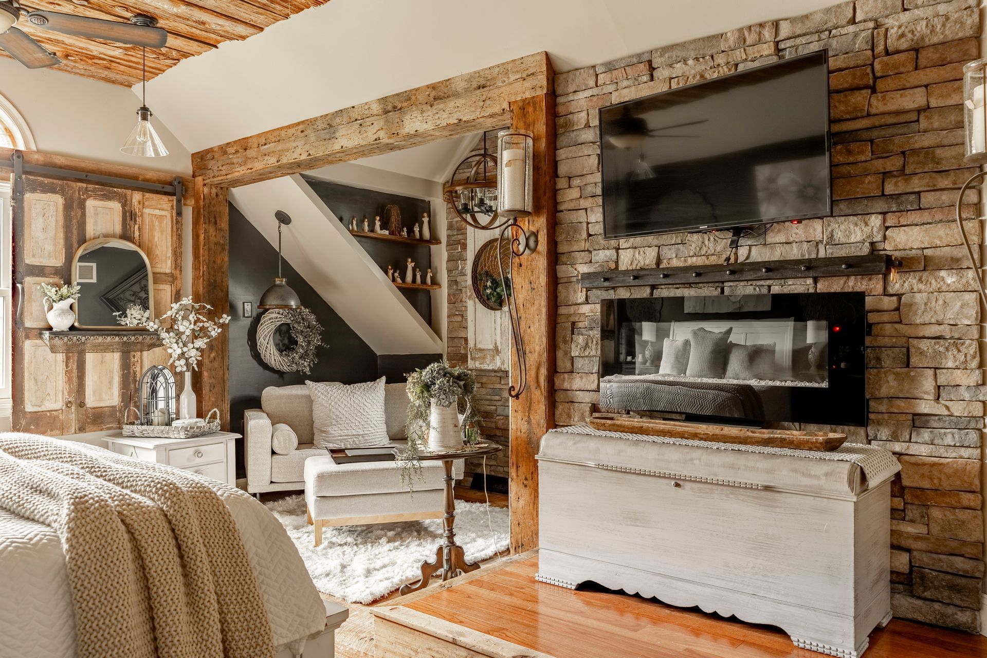 A living room with a fireplace and a flat screen tv on the wall.