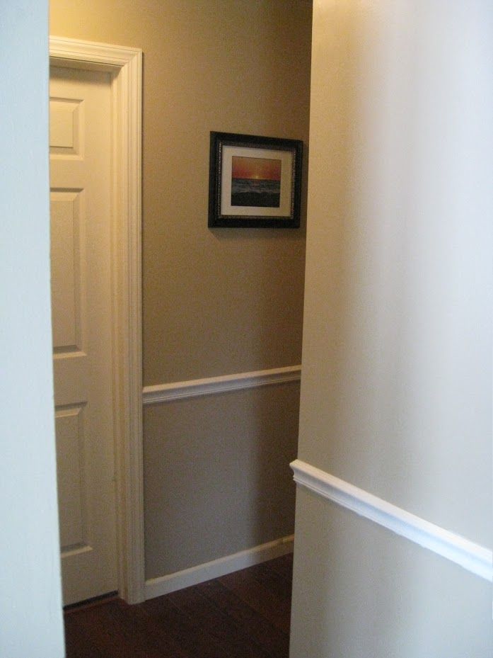 A hallway with a picture on the wall above the door