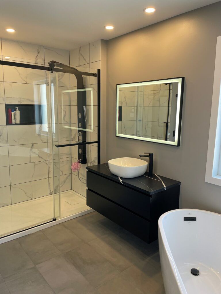 Salle de bains moderne avec douche en verre, meuble-lavabo et baignoire îlot.