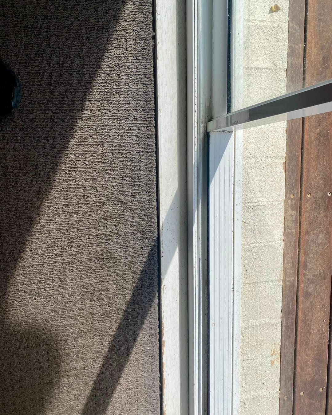 Carpet Edge Meets a Sliding Glass Door Frame on Wooden Flooring — Fix-A-Door in Morisset, NSW