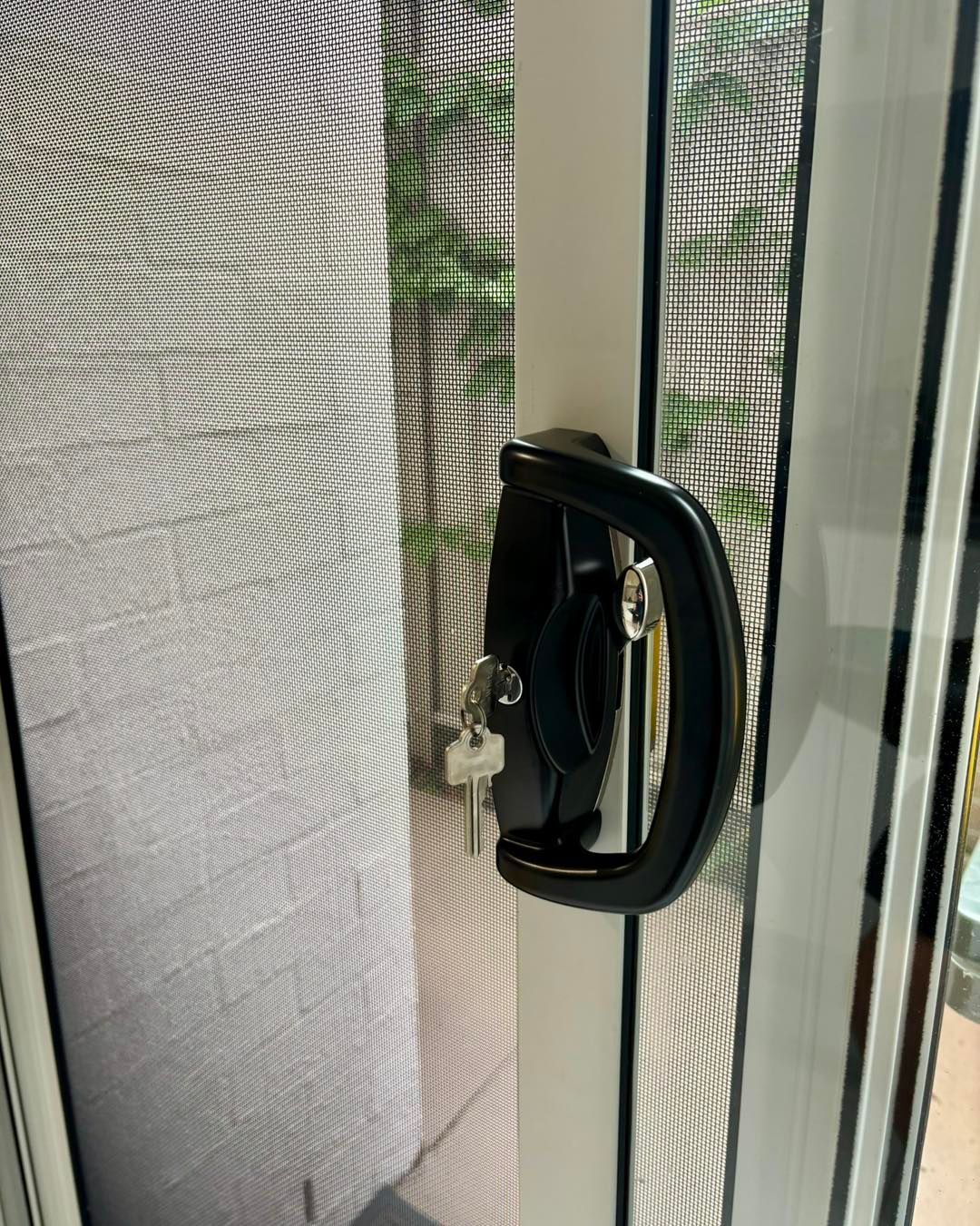 Black Door Handle With Keys, on a White Sliding Glass Door With a Screen — Fix-A-Door in Lake Macquarie, NSW