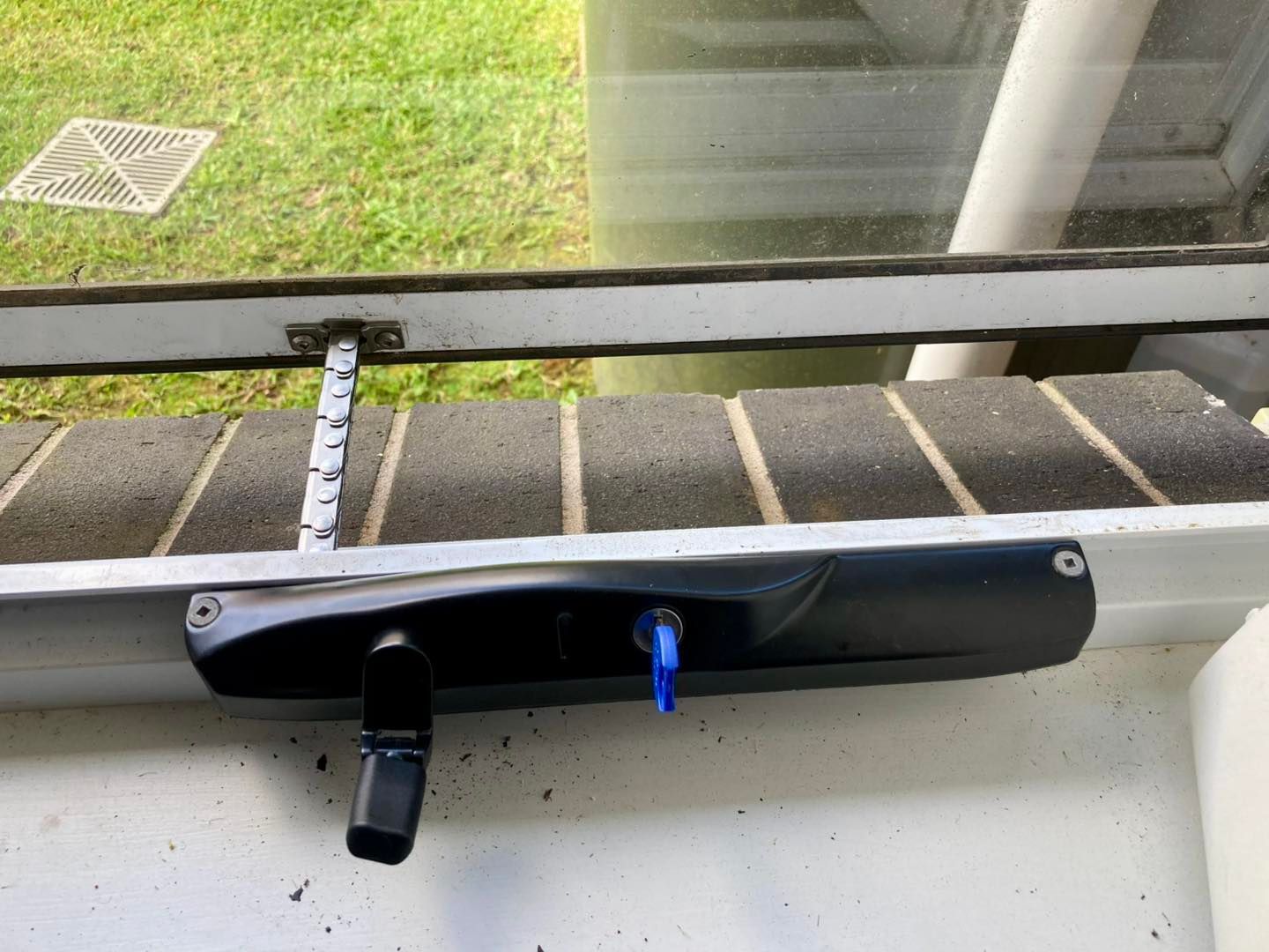 Black Gutter-mounted Security Device With a Lock and Key — Fix-A-Door in Morisset, NSW