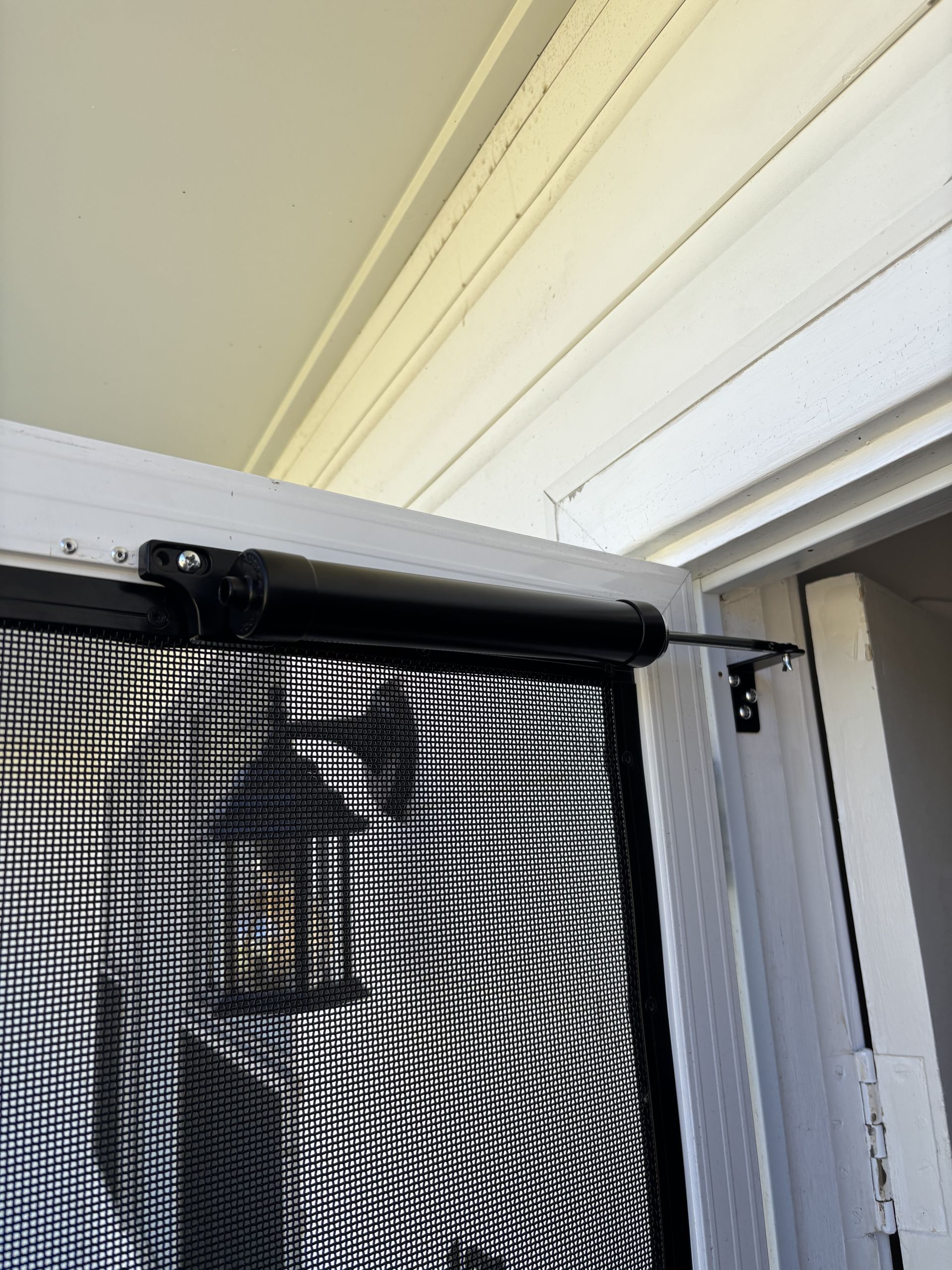 Screen door with black spring-loaded closer attached to a white frame— Fix-A-Door in Morisset, NSW