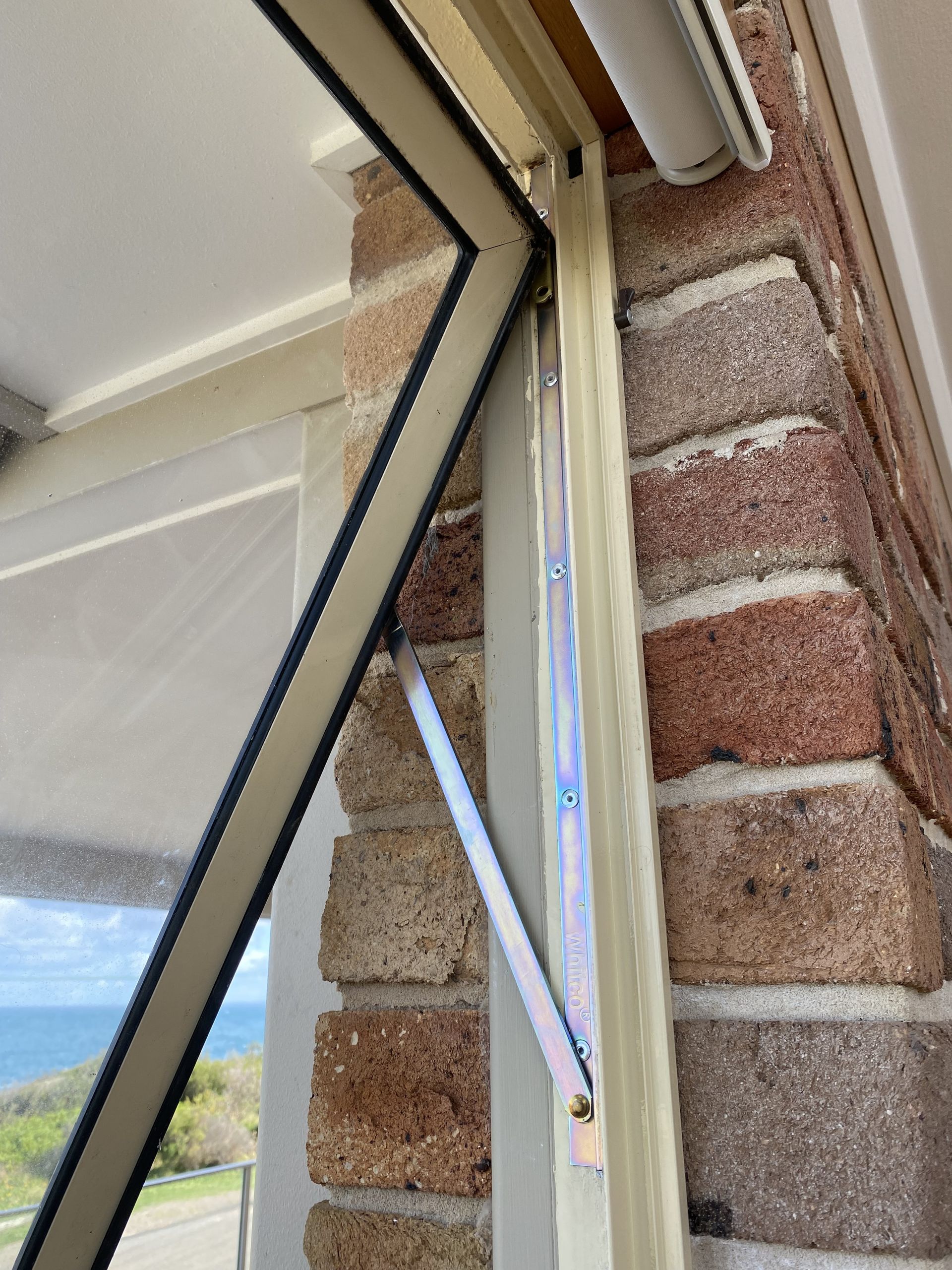 An Open Casement Window With An Arm Support On A Brick Wall — Fix-A-Door in Raymond Terrace, NSW
