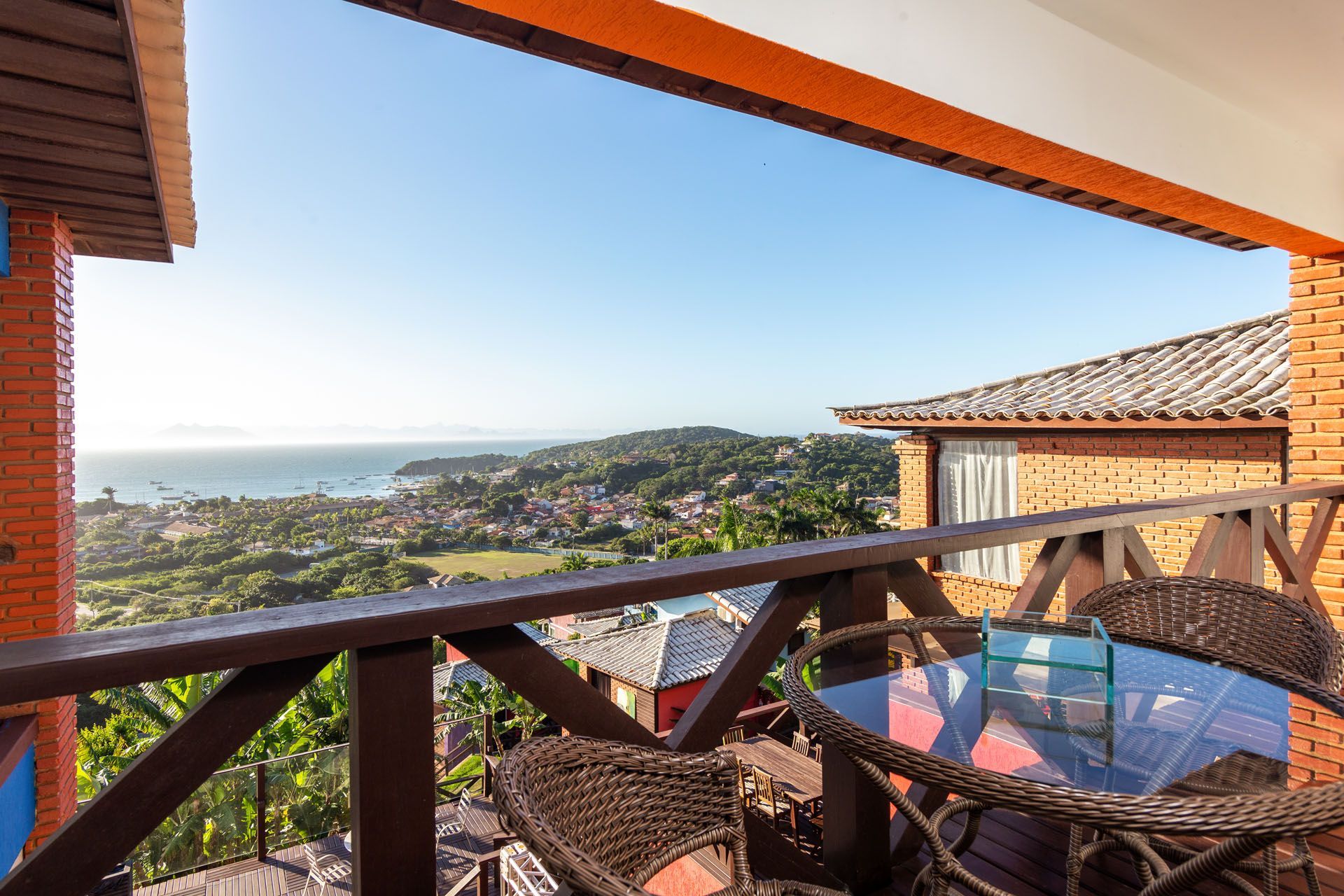 Uma varanda com vista para o oceano e uma mesa e cadeiras.