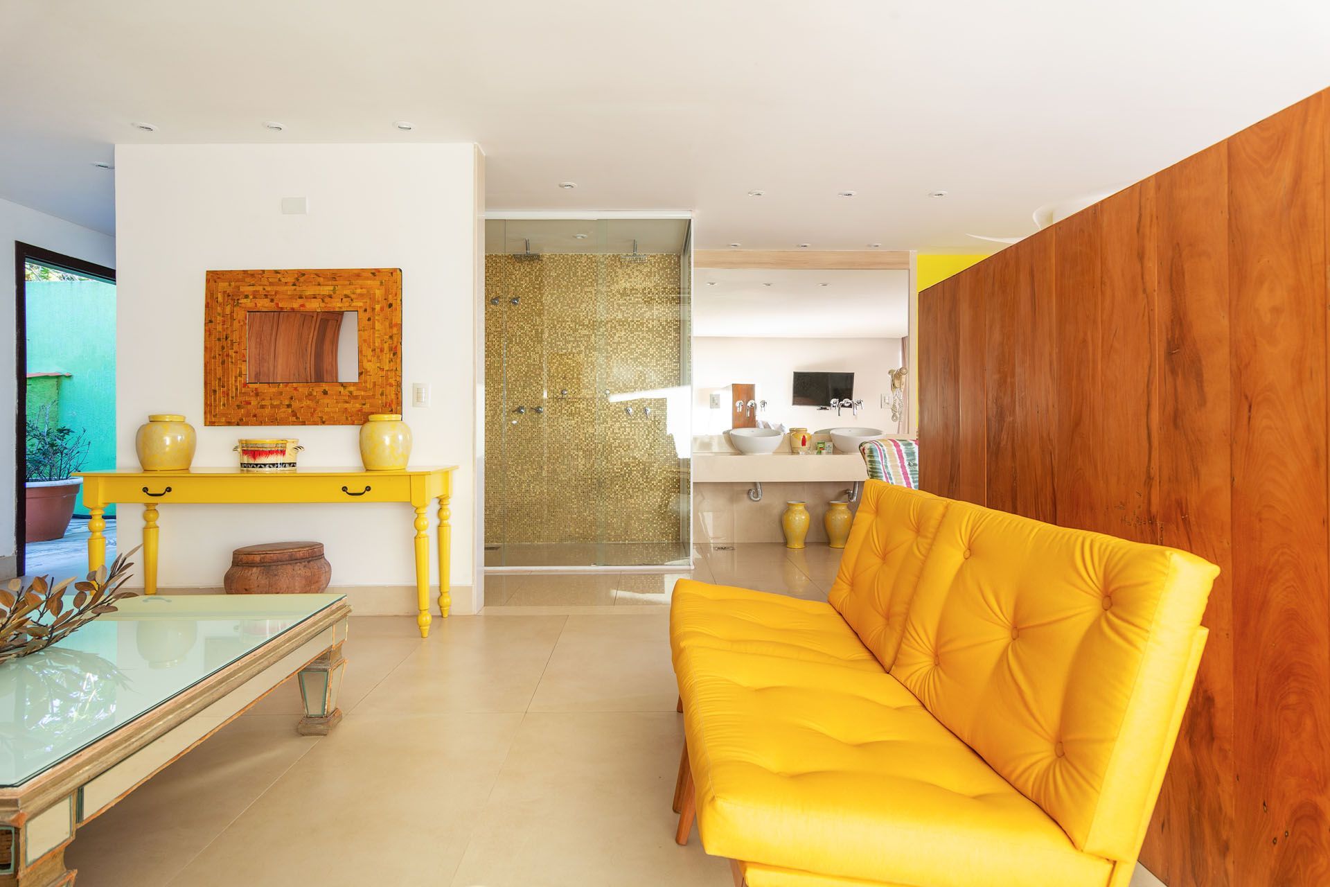 Uma sala de estar com um sofá amarelo e uma mesa amarela