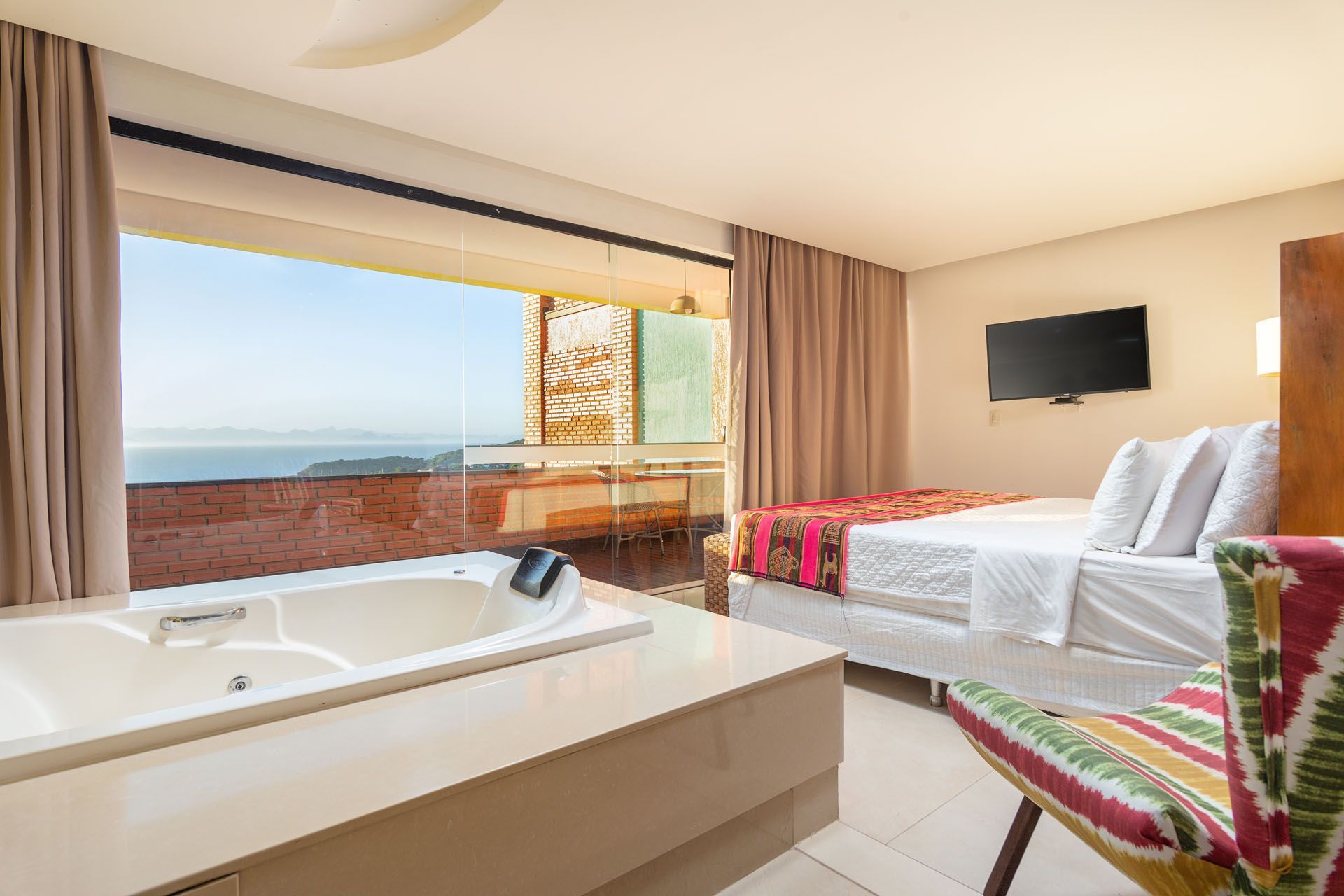 Um quarto de hotel com banheira de hidromassagem e vista para o oceano.