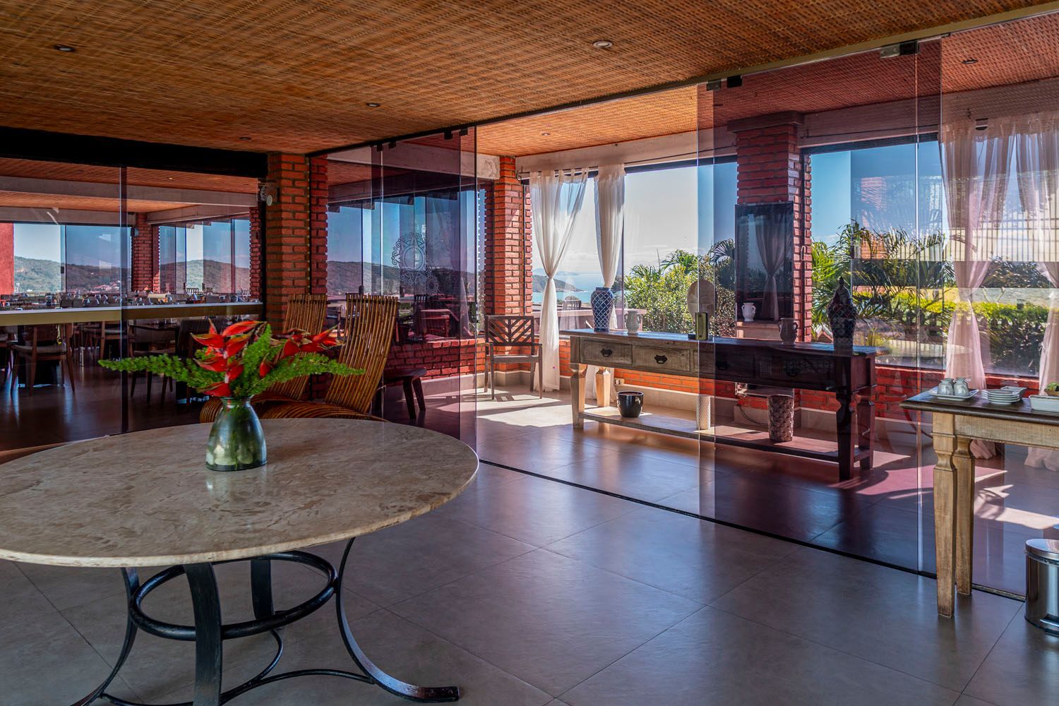 Há uma mesa com um vaso de flores no meio da sala.