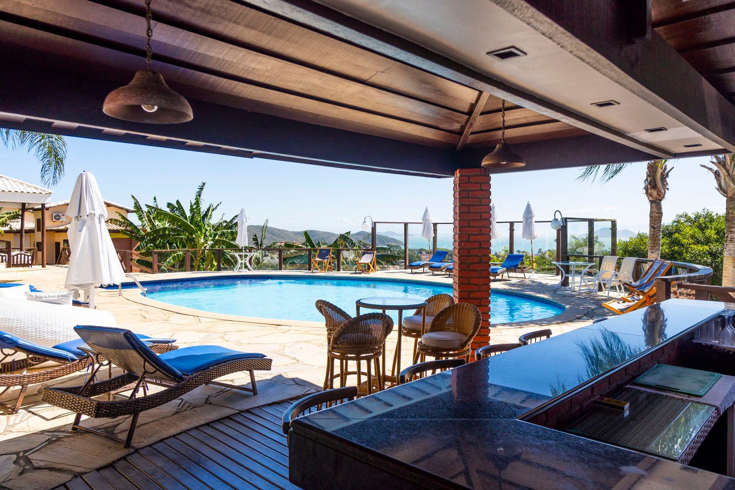 Uma grande piscina com um bar e cadeiras ao redor