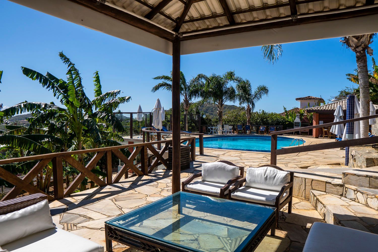 Um pátio com uma mesa e cadeiras e uma piscina ao fundo