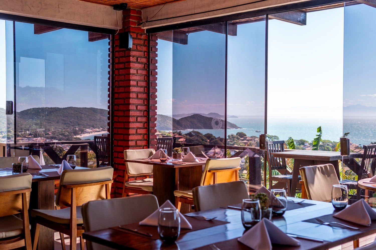 Um restaurante com mesas e cadeiras e vista para o oceano.
