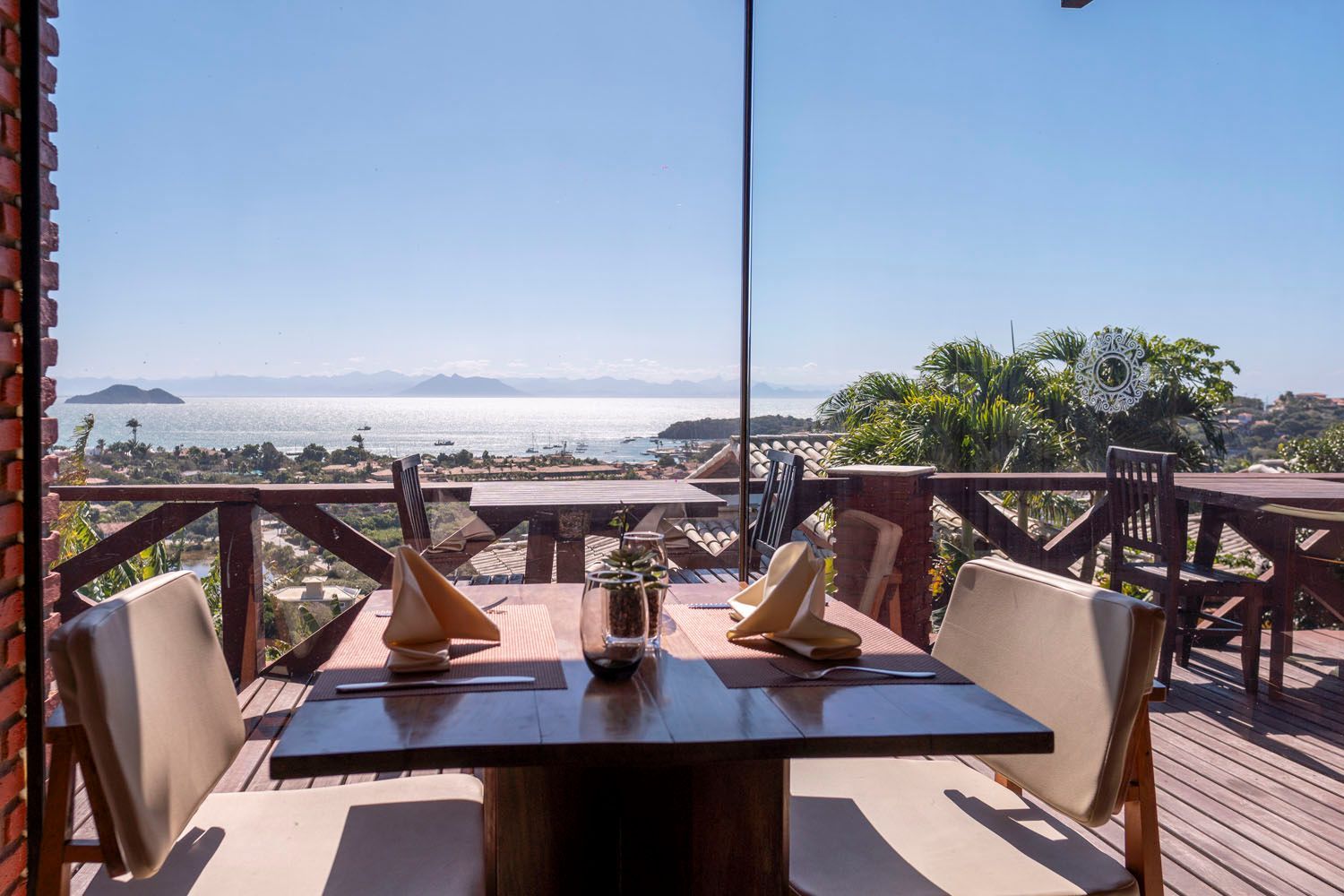 Uma mesa e cadeiras em uma varanda com vista para o oceano.