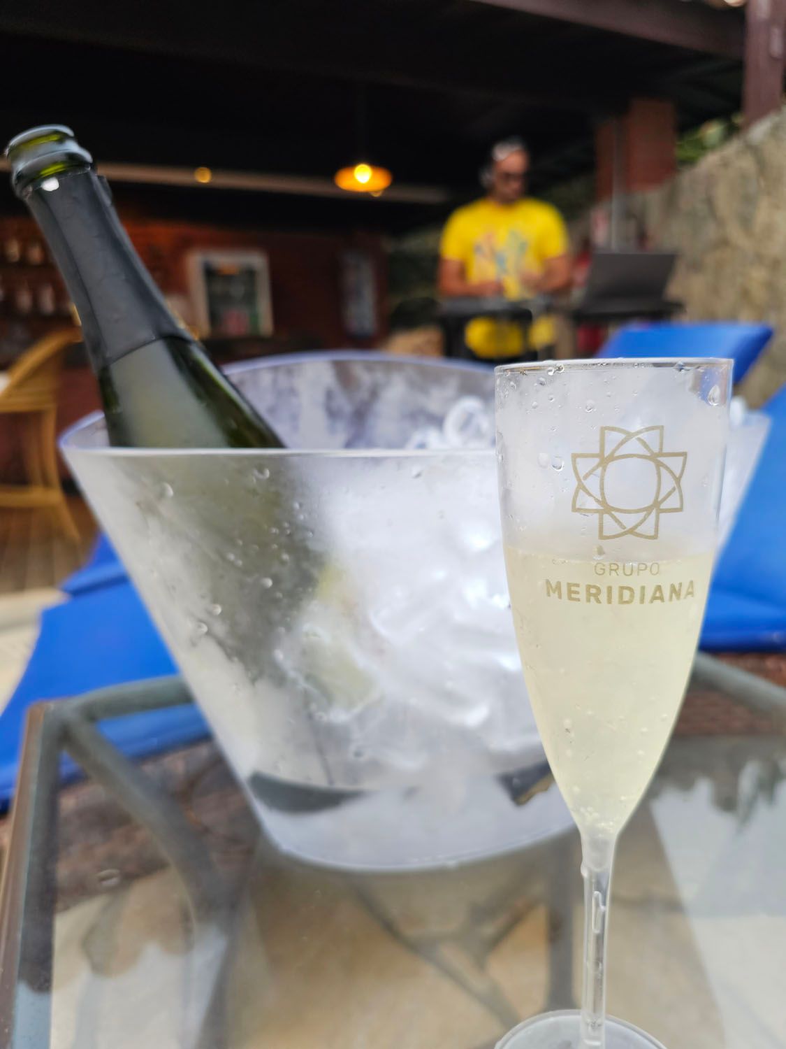 Uma garrafa de champanhe em um balde ao lado de uma taça de champanhe