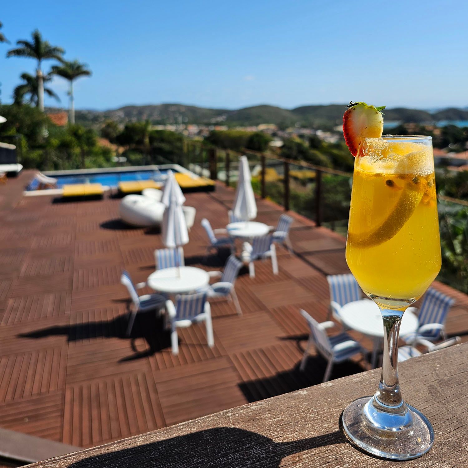 Um copo de líquido amarelo com um morango em cima