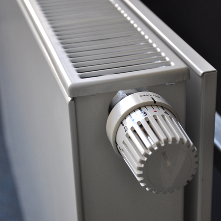 A white radiator with a white thermostat on it