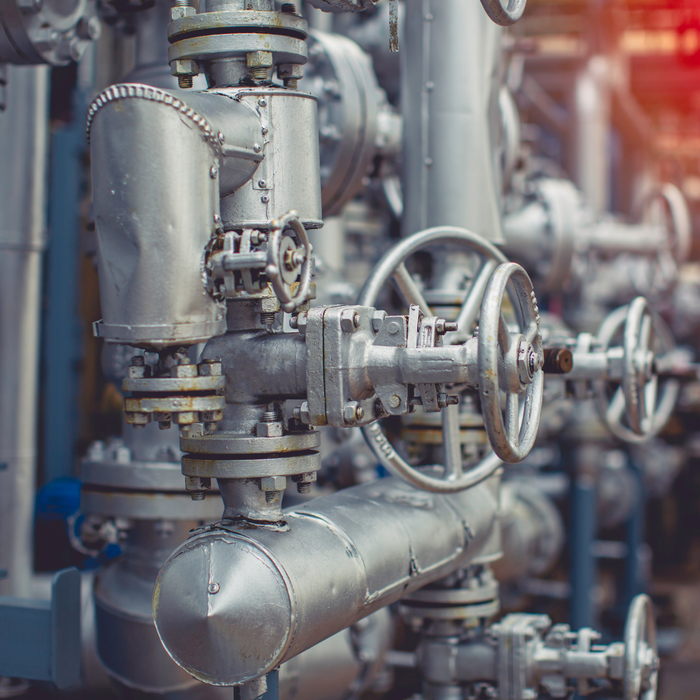 A bunch of metal pipes with valves on them in a factory.