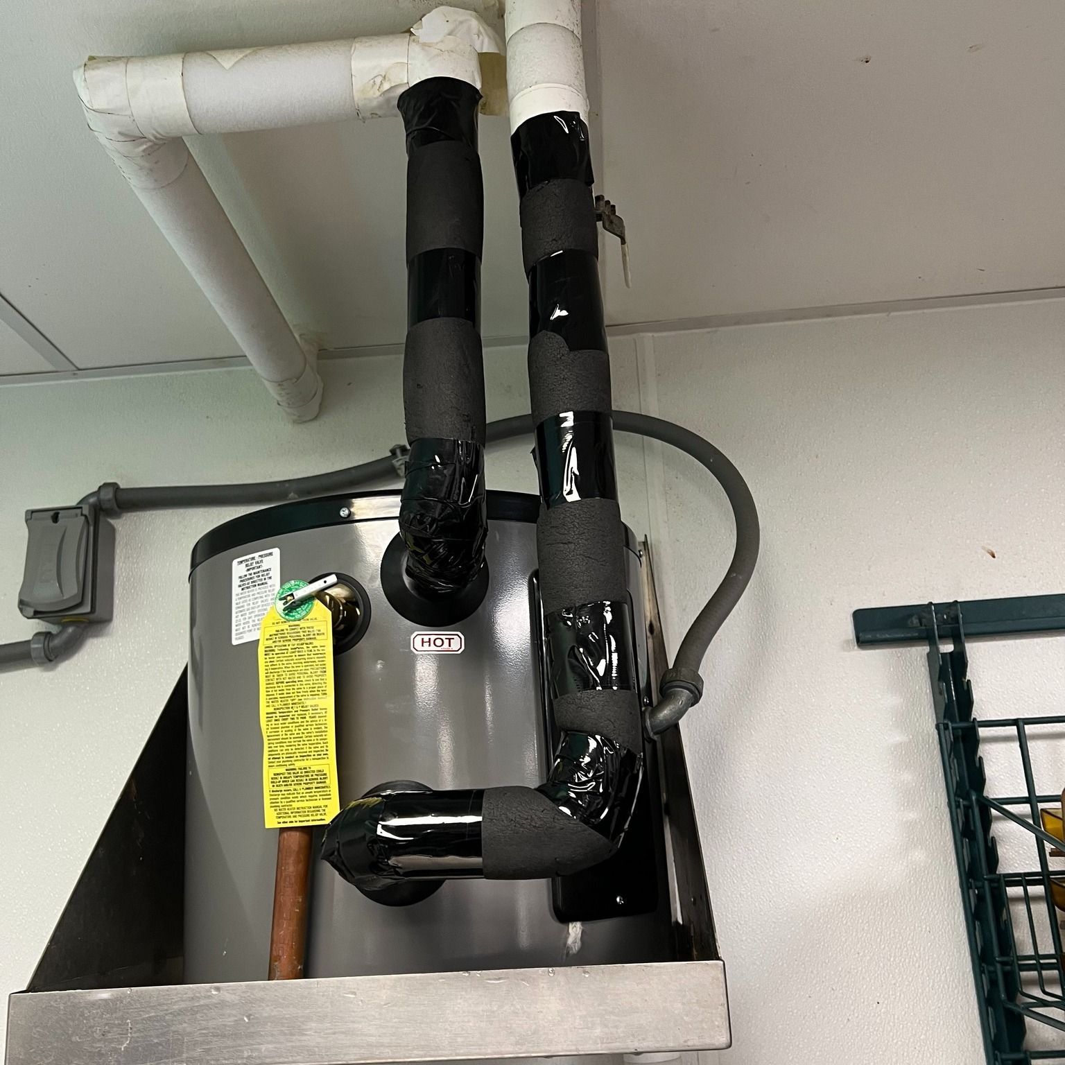 A water heater is hanging from the ceiling in a room.