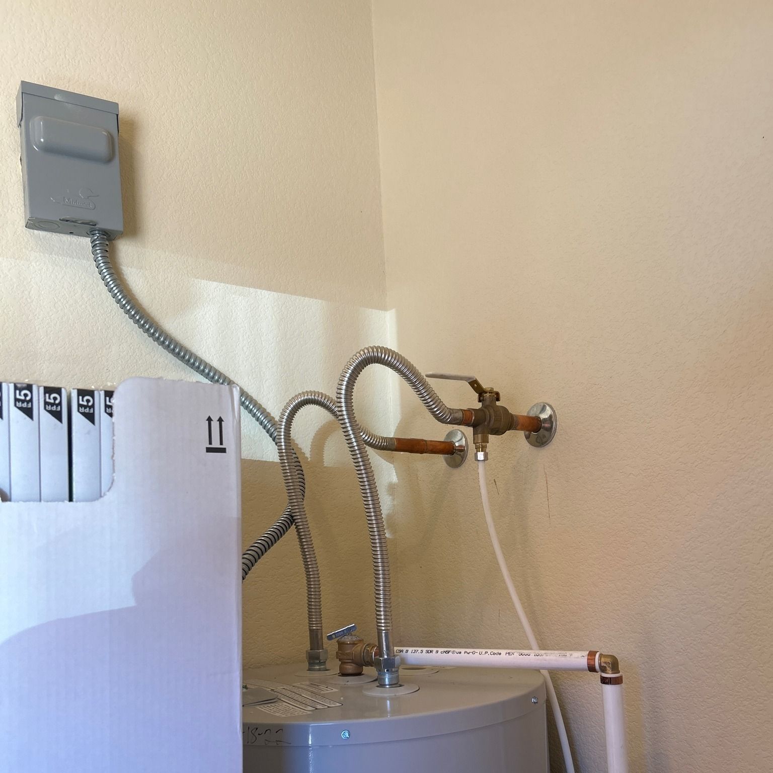 A box with the number 11 on it is next to a water heater