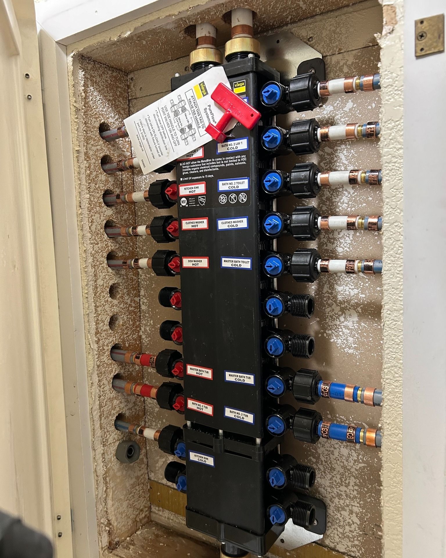 A black box with a lot of tubes and valves inside of it.
