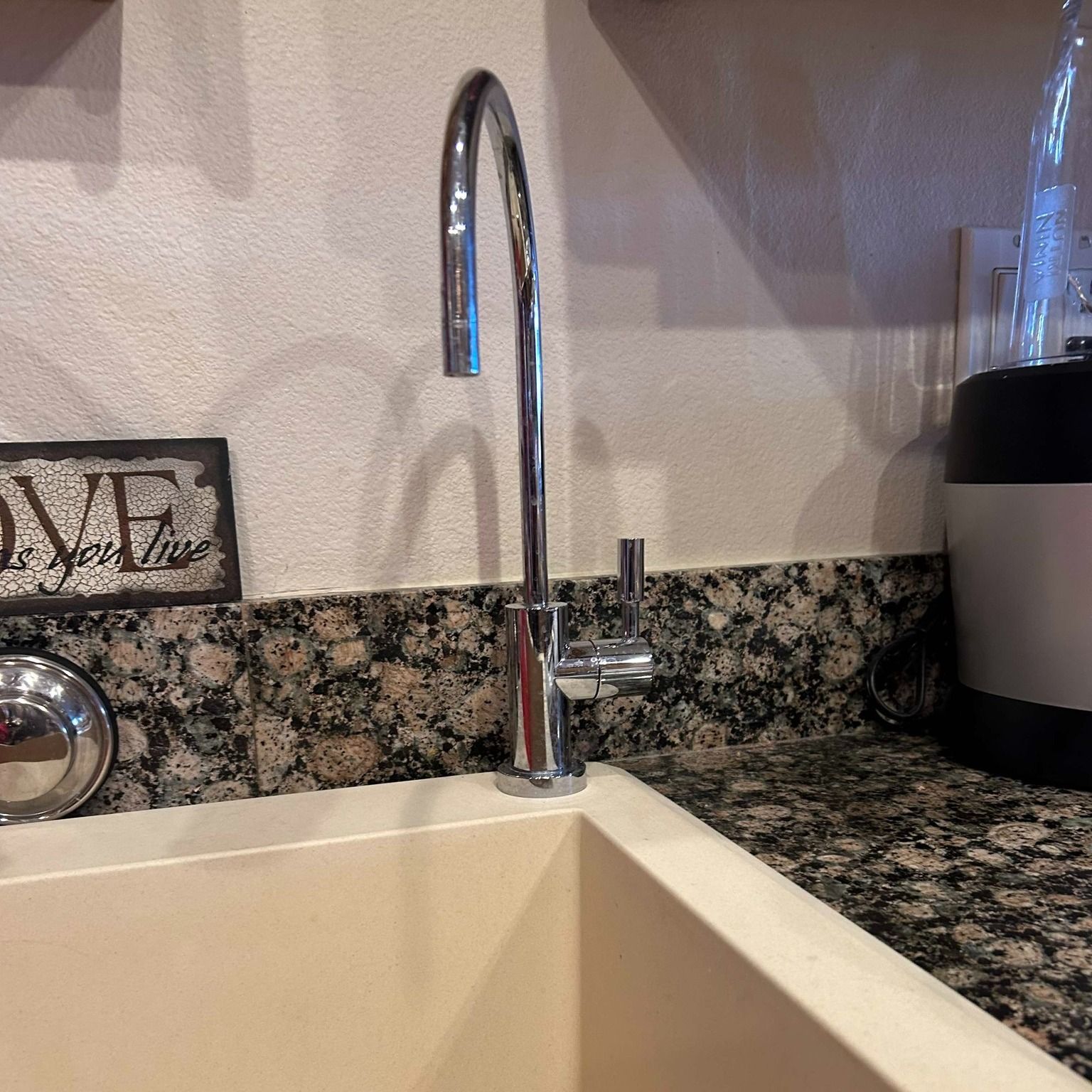 A kitchen sink with a sign that says love on it